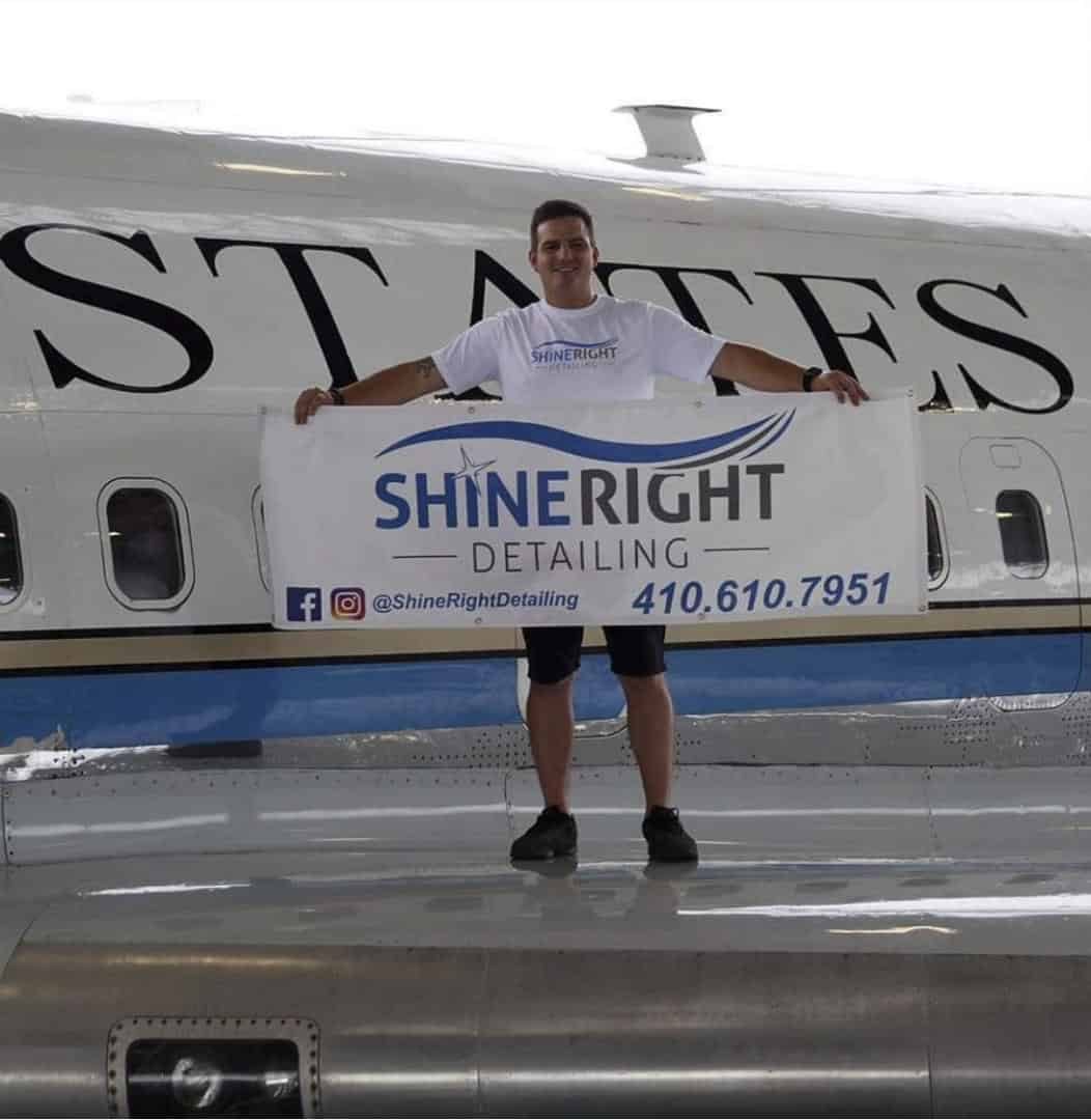 Josh Buckler holding a Shine Right banner in front of the original Air Force One at The Museum of Flight