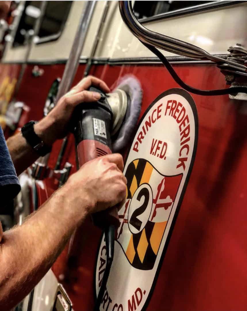 Detailer polishing a Prince Frederick fire engine